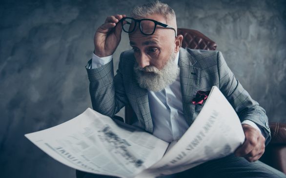Omg! Attractive, astonished boss in suit take off glasses, shocked, impressed from facts, information in newspaper, sitting in leather chair, money, shares, stock, gray background