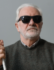 medium shot of blind man with sunglasses and cane