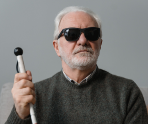 medium shot of blind man with sunglasses and cane