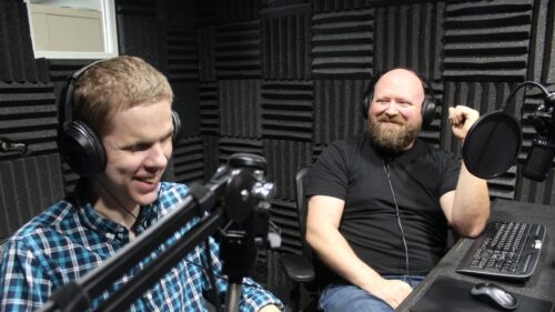 Evan and Jonathan in a podcast studio laughing.